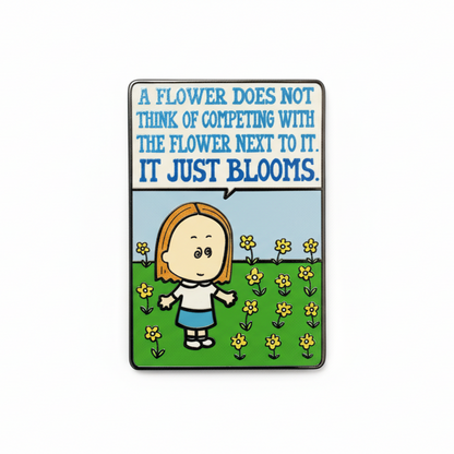 Enamel pin with Maria, a cartoon character and flowers, with a quote 'A flower does not think of competing with the flower next to it, it just blooms.'.